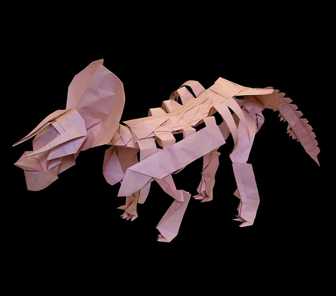This picture shows a beautifully constructed Triceratops origami model set against a black background.