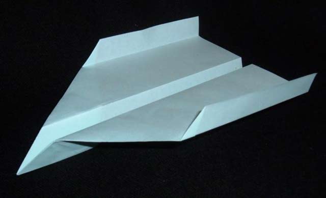 Esta imagem mostra um avião de papel bem desenhado com dobras limpas contra um fundo preto.