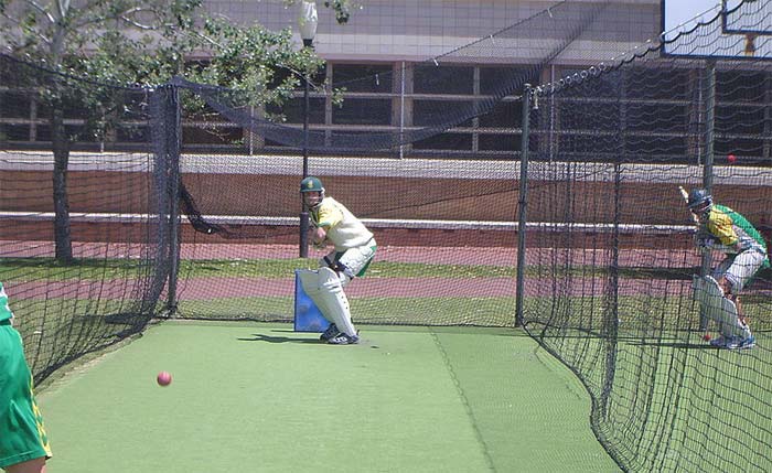 Two batters from the South African cricket team practice in the nets, facing deliveries from their team mates.