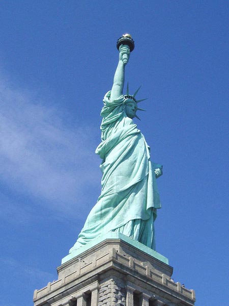 This photo looks up at the famous Statue of Liberty that is located on Liberty Island, in the harbor of New York, USA. The well known statue was gifted to the United States by the French as a gift to commemorate the one hundred year anniversary of the signing of the Declaration of Independence.