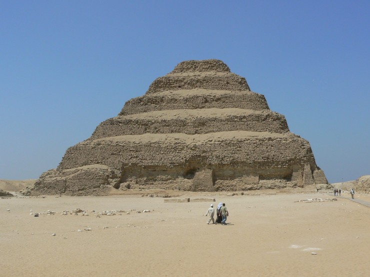This photo shows the Step Pyramid of Djoser on a beautiful sunny day near the city of Memphis in Egypt. The pyramid stands 62 metres (203 feet) tall. Its immense size can be clearly seen when contrasted against the seemingly small people walking in front of and beside the giant landmark.