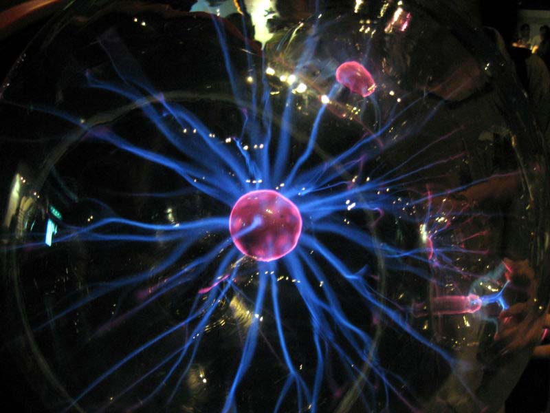 This close up photo shows a plasma ball in action while being contained inside a spherical case.
