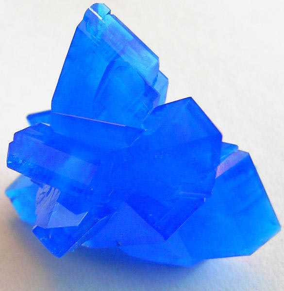 This photo shows a close up view of copper sulphate crystals. These crystals feature a beautiful color and are easy to grow, making them a popular choice for chemistry education.
