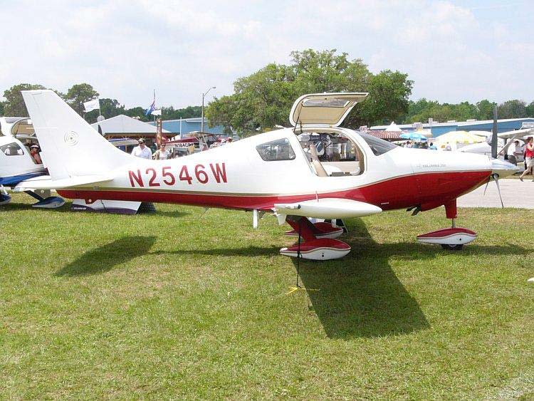 A side on photo of a Cessna 350 displayed at an aviation show. Other planes can be seen in the background as well as people attending the event. 