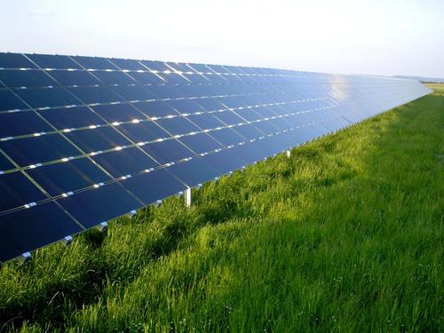 A large row of solar energy panels can be seen in this photo. As they face the sun they absorb the solar energy which can then be turned into electricity and used to power any number of useful objects.