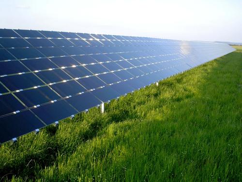 A large row of solar energy panels can be seen in this photo. As they face the sun they absorb the solar energy which can then be turned into electricity and used to power any number of useful objects.