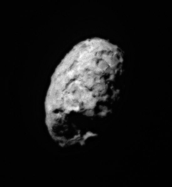 A slightly blurry photo of a distant comet set against the dark background of space.