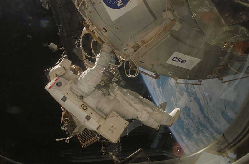 A unique photo of an astronaut as they perform complicated maintenance during a space walk.