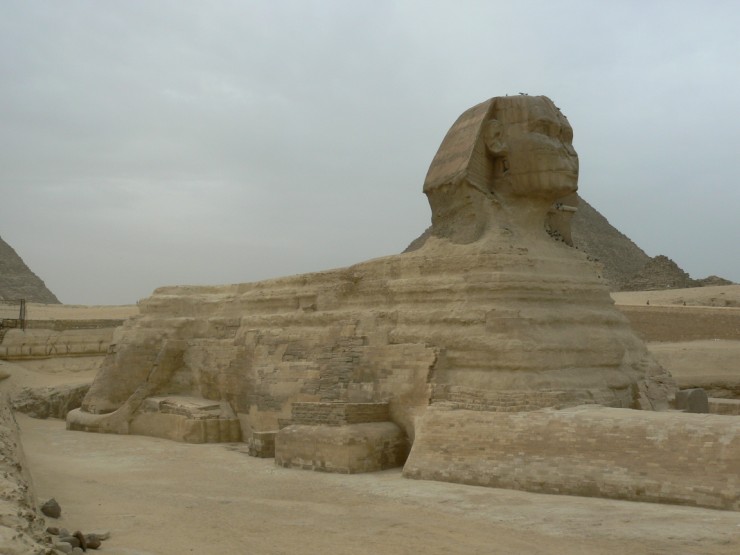 The Great Sphinx of Giza is a well known statue built during Ancient Egypt. It features a lion with a human head and stands over 20 metres (66 feet) high and 70 metres (240 feet) long. This photo of the Great Sphinx of Giza was taken from the side which helps show its amazing length. Two pyramids can also be partially seen in the background.