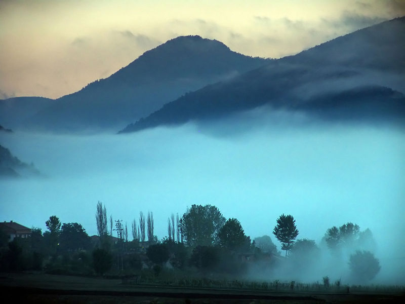 This excellent photo shows valley mist creeping through the hills and even getting as low as the houses and trees visible on the ground.